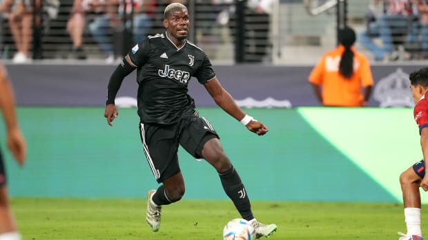 Paul Pogba dribbles the ball in a black Juventus uniform
